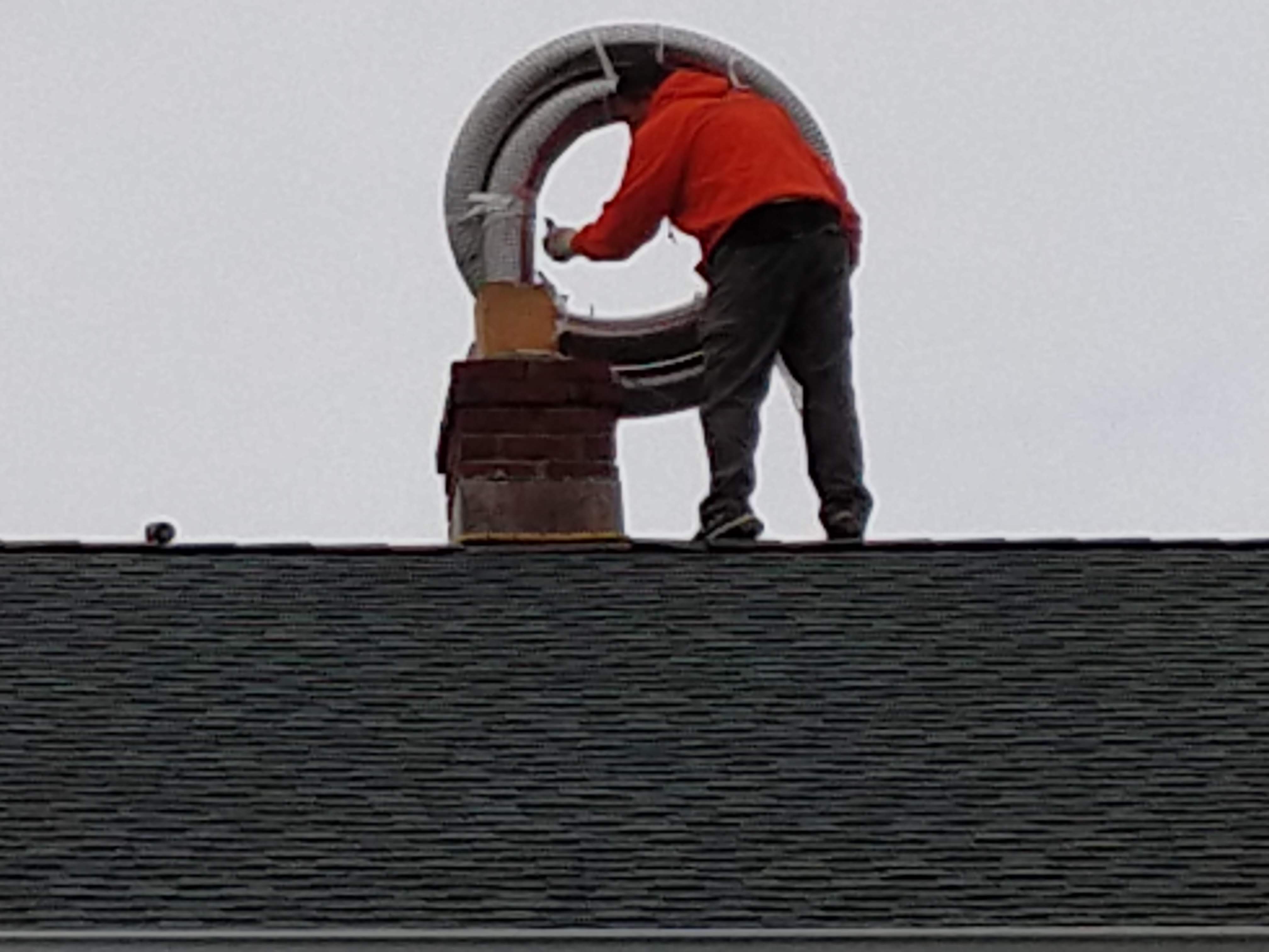 Flexible stainless chimney liner being installed in East Northport, New York